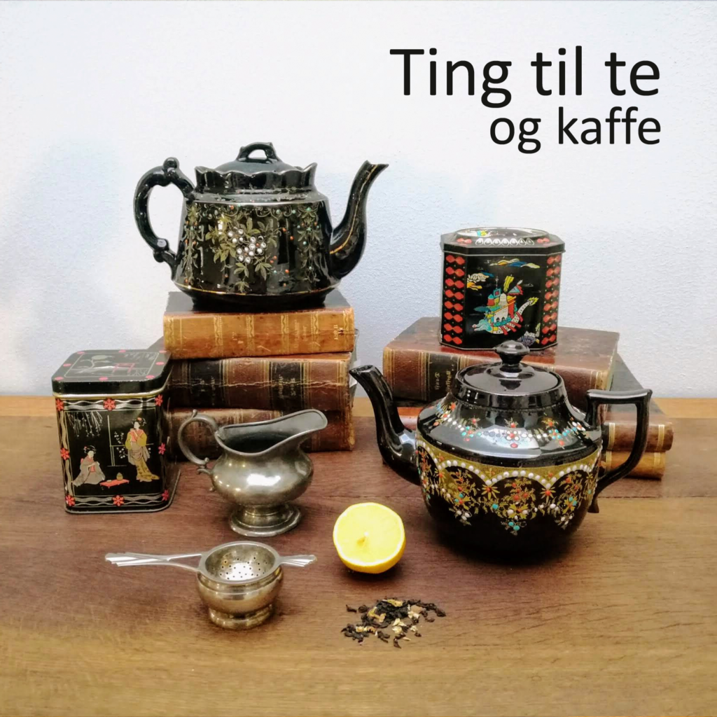 Tekande, tepotte, tedåser omgivet af en mælkekande i sølv, en sølvtesi, en halv citron og lidt lidt løs te - arrangeret på smukke antikvariske lædderindbundne bøger